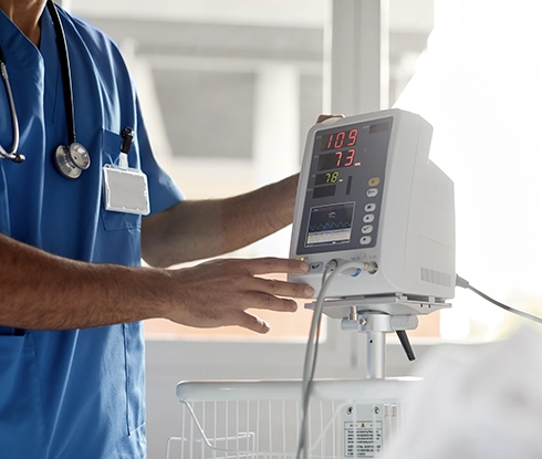 An EKG technician changes the settings on an EKG machine