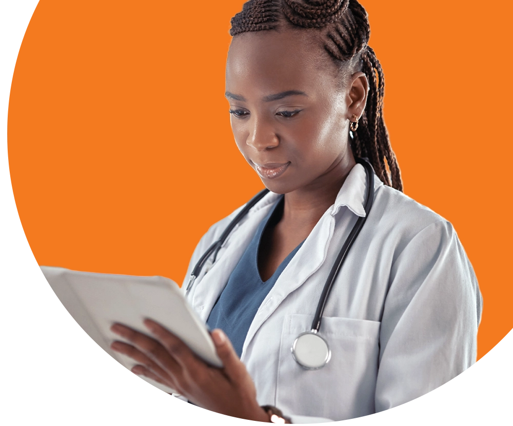 A doctor wearing a labcoat looks at a tablet