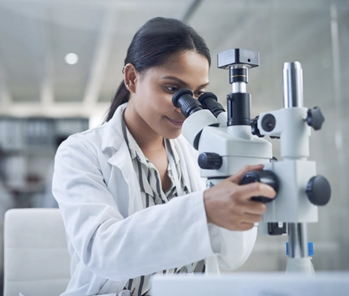  A medical professional looks through a microscope