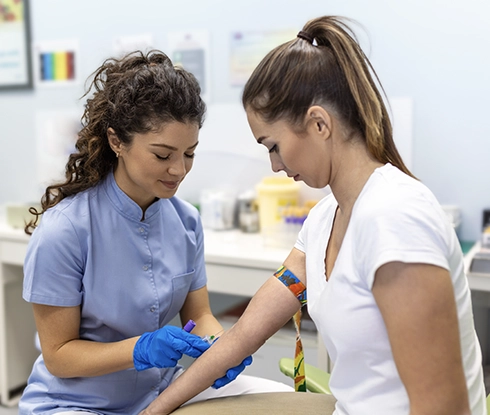 A medical professional prepares a patient for getting their blood drawn.