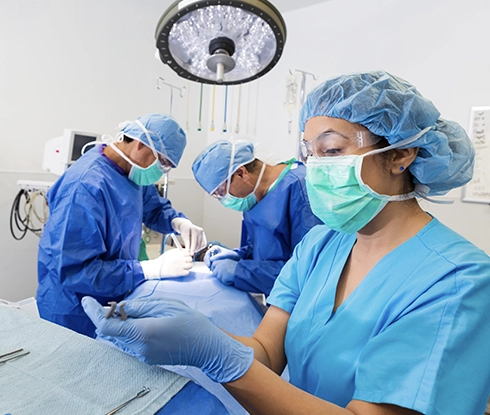 A medical professional wearing scrubs prepares tools ready for surgery